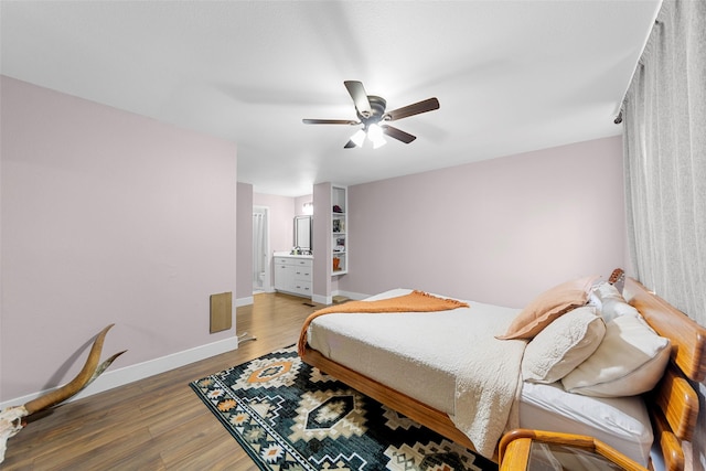 8400 Hickory St Unit 103, Frisco, TX 75034 - bedroom with wood finished floors, baseboards, ceiling fan, and ensuite bathroom