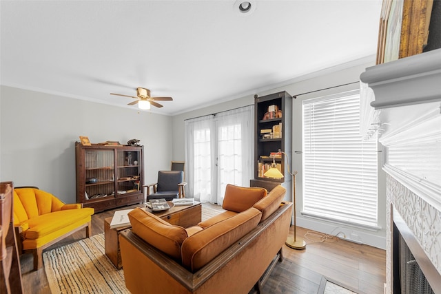 8400 Hickory St Unit 103, Frisco, TX 75034 - living room featuring ceiling fan, ornamental molding, a fireplace, and wood finished floors