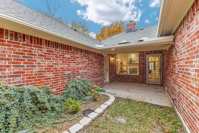 1275 Shores Blvd, Rockwall, TX 75087 - entrance to property with brick siding, roof with shingles, a patio area, and a chimney