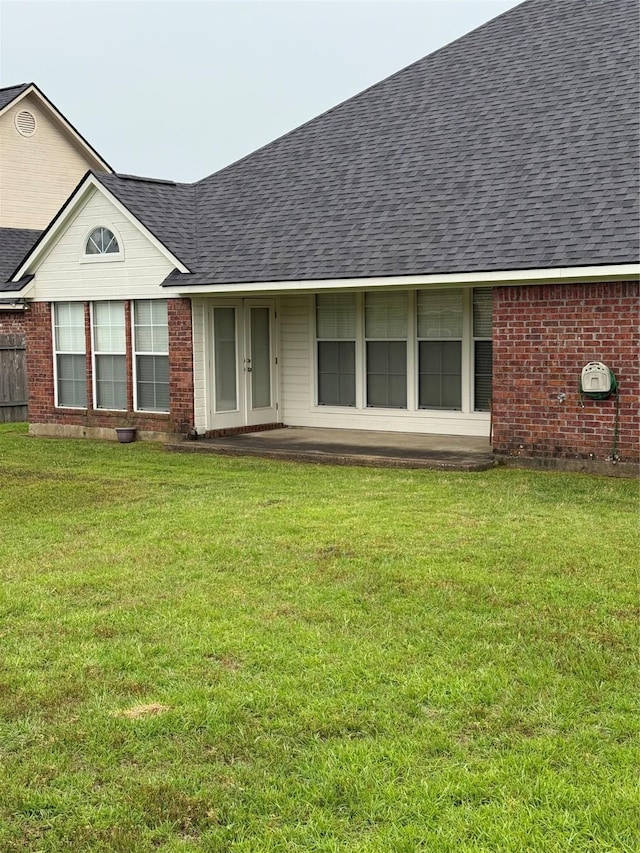 5714 Ferrell Dr, Shreveport, LA 71129 - back of house with a shingled roof, a lawn, and brick siding