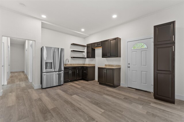 1601 N 11th St, Waco, TX 76707 - kitchen featuring stainless steel refrigerator with ice dispenser, light wood finished floors, dark brown cabinets, light countertops, and open shelves