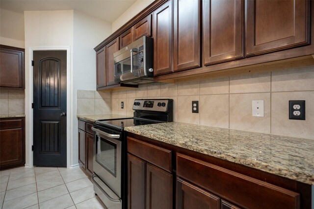 1543 Meadowlake Dr, Waxahachie, TX 75165 - kitchen with stainless steel appliances, backsplash, light stone counters, light tile patterned floors, and dark brown cabinetry