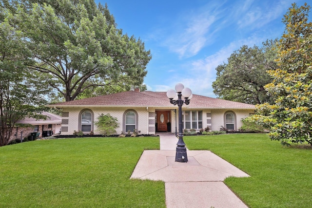 8820 Hunters Glen Trl, Fort Worth, TX 76120 - view of front facade with a front yard, a chimney, brick siding, and a shingled roof