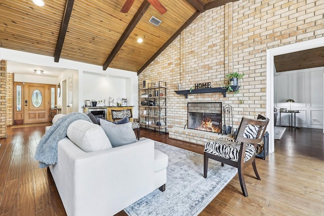 8820 Hunters Glen Trl, Fort Worth, TX 76120 - living room with wood-type flooring, wooden ceiling with exposed beams, a fireplace, high vaulted ceiling, and brick wall