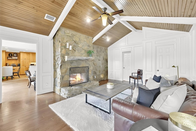 8820 Hunters Glen Trl, Fort Worth, TX 76120 - living room featuring wooden ceiling, a ceiling fan, a stone fireplace, and wood finished floors