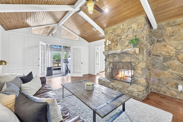 8820 Hunters Glen Trl, Fort Worth, TX 76120 - living room with wooden ceiling with exposed beams, french doors, wood finished floors, a ceiling fan, and a stone fireplace