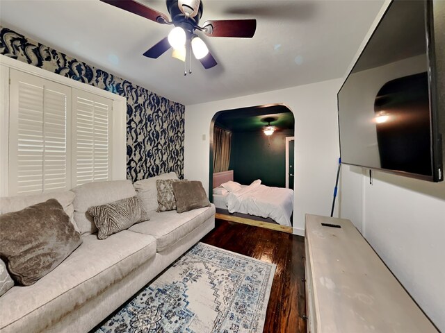 3127 Pastor St, Dallas, TX 75212 - bedroom featuring wood finished floors, arched walkways, wallpapered walls, an accent wall, and ceiling fan