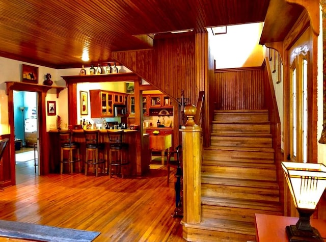 1001 S Locust St, Clarksville, TX 75426 - stairway with a bar, wood finished floors, wooden ceiling, and wood walls