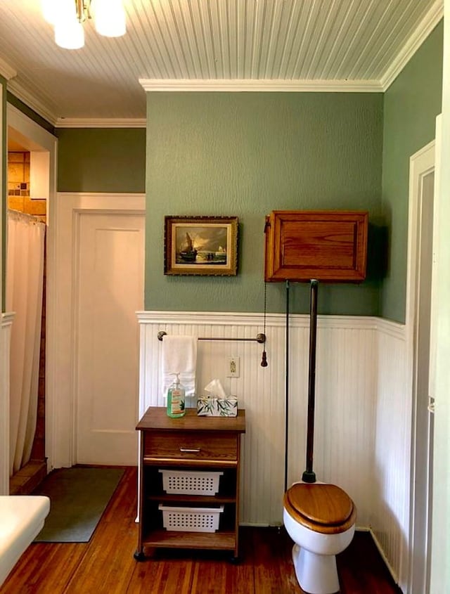 1001 S Locust St, Clarksville, TX 75426 - full bathroom featuring crown molding, wood finished floors, wainscoting, a shower with curtain, and toilet
