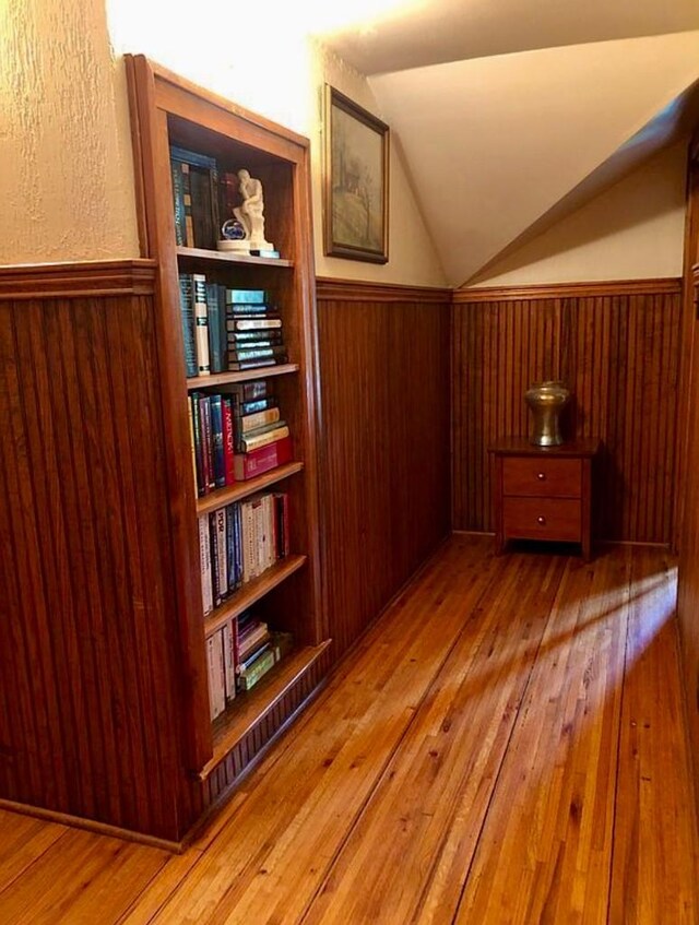 1001 S Locust St, Clarksville, TX 75426 - bonus room with a wainscoted wall, vaulted ceiling, hardwood / wood-style floors, and wooden walls