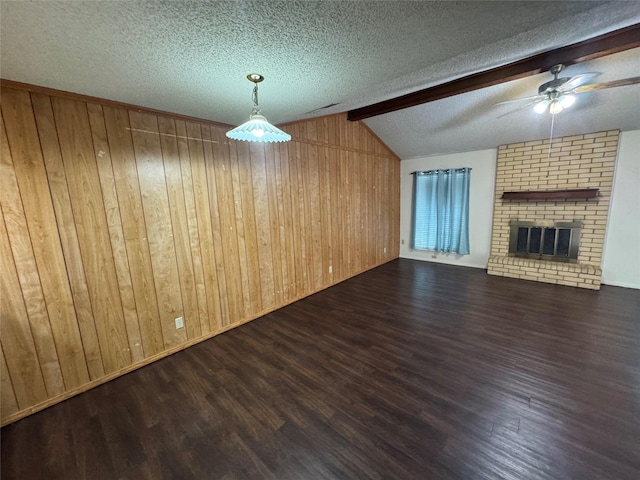 397 Somerset Pl, Abilene, TX 79601 - unfurnished living room featuring wood finished floors, ceiling fan, wood walls, a textured ceiling, and a brick fireplace
