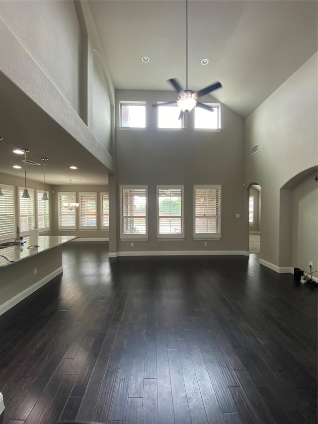 4434 Vineyard Creek Dr, Grapevine, TX 76051 - unfurnished living room featuring ceiling fan, a high ceiling, wood-type flooring, arched walkways, and baseboards