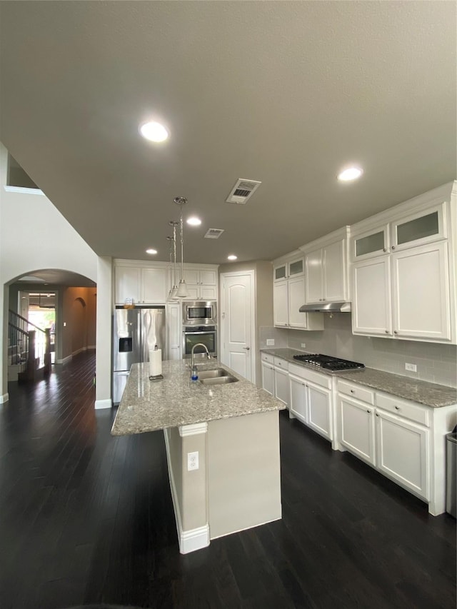 4434 Vineyard Creek Dr, Grapevine, TX 76051 - kitchen with arched walkways, stainless steel appliances, a sink, baseboards, and white cabinetry