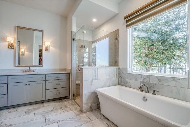 6009 Westchester Ln, Frisco, TX 75034 - bathroom with a stall shower, vanity, a freestanding tub, marble look tile flooring, and recessed lighting