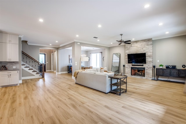 6009 Westchester Ln, Frisco, TX 75034 - living room with ceiling fan, ornamental molding, a stone fireplace, stairs, and recessed lighting