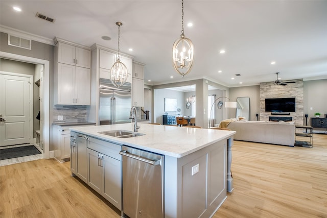 6009 Westchester Ln, Frisco, TX 75034 - kitchen featuring a chandelier, stainless steel appliances, a sink, ornamental molding, and a ceiling fan