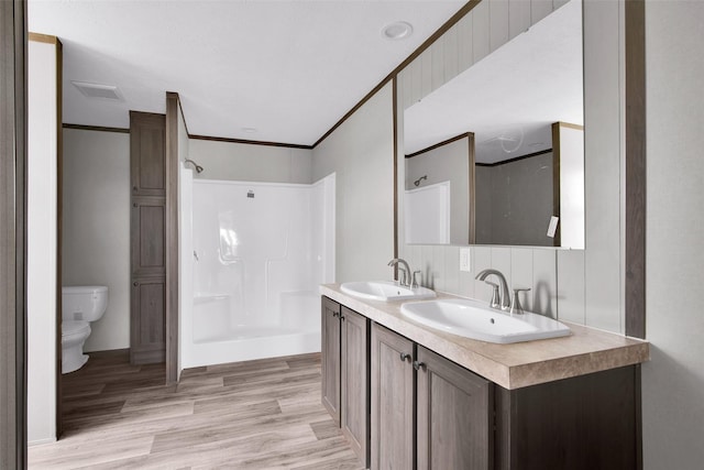 1203 Old Ida Rd, Sherman, TX 75090 - bathroom featuring a shower, toilet, wood finished floors, double vanity, and baseboards