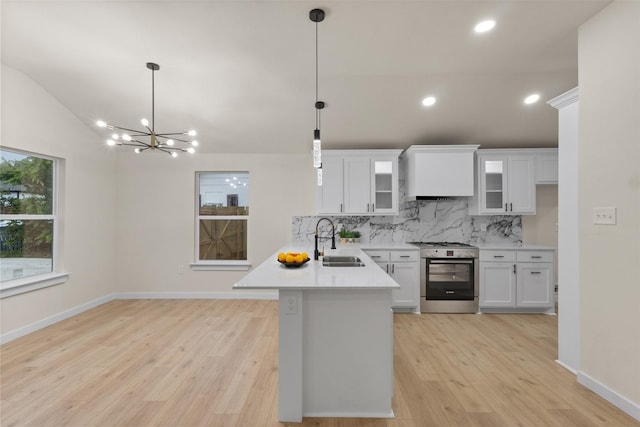 1832 Arch St, Fort Worth, TX 76105 - kitchen featuring stainless steel range with gas cooktop, a sink, a peninsula, tasteful backsplash, and light wood-style floors