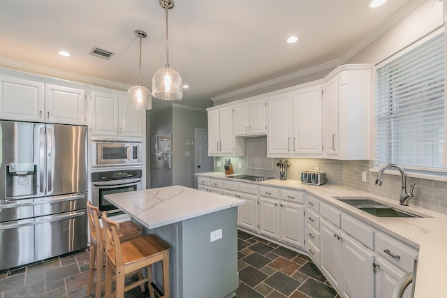 415 Saddle Tree Trl, Coppell, TX 75019 - kitchen with appliances with stainless steel finishes, a sink, white cabinetry, ornamental molding, and dark stone finish floors