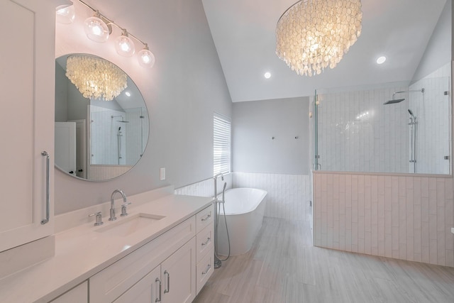 415 Saddle Tree Trl, Coppell, TX 75019 - full bathroom with vaulted ceiling, a chandelier, a stall shower, vanity, and a freestanding bath