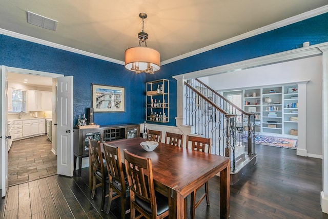 415 Saddle Tree Trl, Coppell, TX 75019 - dining space featuring crown molding, dark wood-style floors, a chandelier, and plenty of natural light