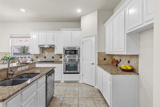 906 Cougar Dr, Allen, TX 75013 - kitchen with stainless steel appliances, a sink, white cabinetry, decorative backsplash, and light stone counters
