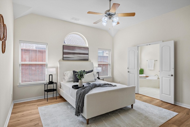 906 Cougar Dr, Allen, TX 75013 - bedroom featuring light wood-type flooring, multiple windows, lofted ceiling, ensuite bathroom, and baseboards