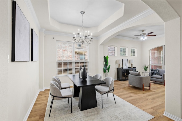906 Cougar Dr, Allen, TX 75013 - dining room with arched walkways, light wood-type flooring, a chandelier, a raised ceiling, and plenty of natural light