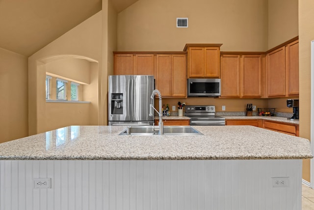 632 Shotwell St, Crowley, TX 76036 - kitchen with stainless steel appliances, a sink, high vaulted ceiling, an island with sink, and light stone counters