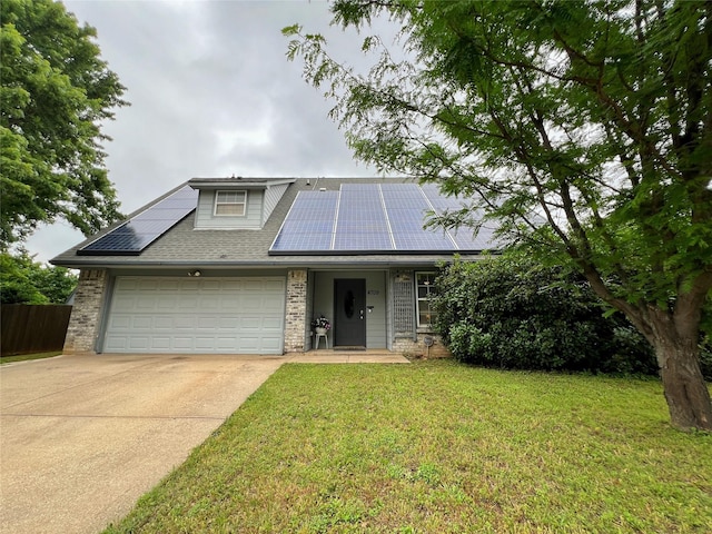 view of front of house featuring an attached garage, driveway, roof mounted solar panels, brick siding, and a shingled roof