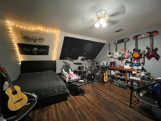 bedroom with wood finished floors, a textured ceiling, and a ceiling fan