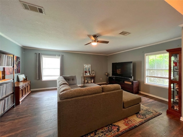 living room with ornamental molding, dark wood finished floors, a ceiling fan, baseboards, and a textured ceiling