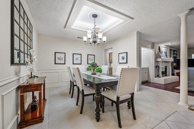 4006 Thornhill Way, Rowlett, TX 75088 - dining area with a textured ceiling, a brick fireplace, light tile patterned floors, a chandelier, and a decorative wall