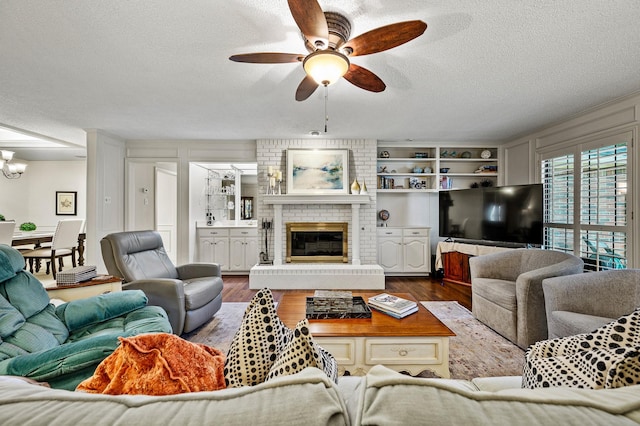4006 Thornhill Way, Rowlett, TX 75088 - living room with a textured ceiling, a ceiling fan, dark wood-type flooring, a chandelier, and a fireplace