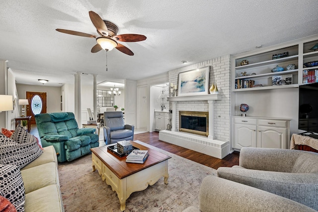 4006 Thornhill Way, Rowlett, TX 75088 - living area featuring a ceiling fan, wood finished floors, a textured ceiling, a chandelier, and a fireplace