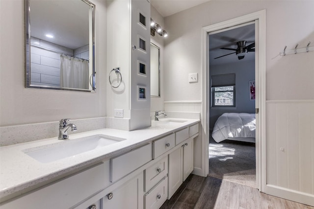 7403 Authon Dr, Dallas, TX 75248 - ensuite bathroom featuring ceiling fan, wood finished floors, wainscoting, and double vanity