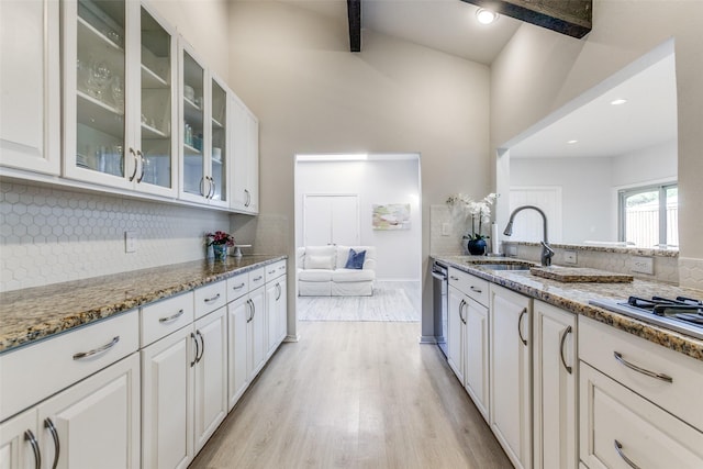 7403 Authon Dr, Dallas, TX 75248 - kitchen with a sink, light wood finished floors, tasteful backsplash, light stone counters, and glass insert cabinets