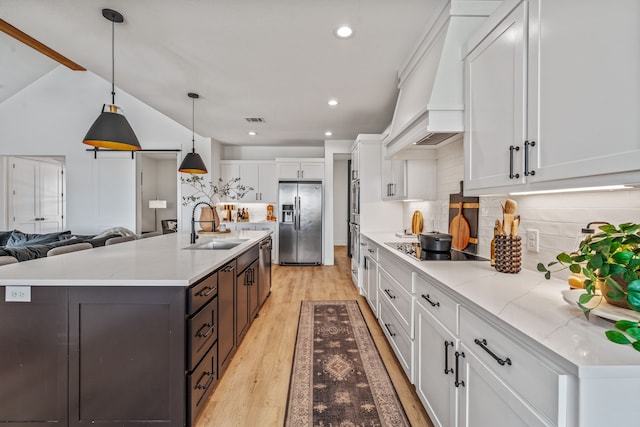 5219 Old Dennis Rd, Weatherford, TX 76087 - kitchen with stainless steel appliances, a sink, white cabinetry, premium range hood, and decorative backsplash