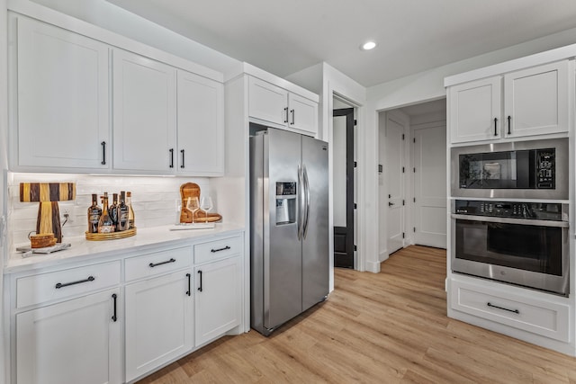 5219 Old Dennis Rd, Weatherford, TX 76087 - kitchen with stainless steel appliances, white cabinetry, light wood-style floors, backsplash, and recessed lighting