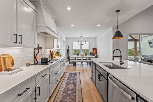 5219 Old Dennis Rd, Weatherford, TX 76087 - kitchen with dishwasher, black electric stovetop, a sink, a chandelier, and light wood-type flooring