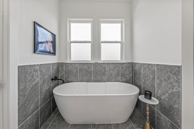 5219 Old Dennis Rd, Weatherford, TX 76087 - bathroom featuring tile walls, a freestanding tub, and a wainscoted wall