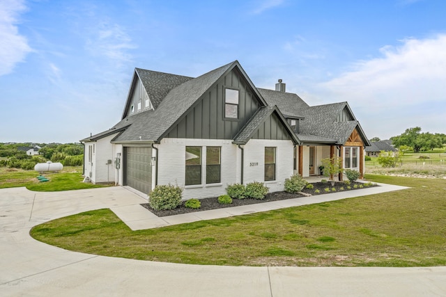 5219 Old Dennis Rd, Weatherford, TX 76087 - view of front of home featuring board and batten siding, concrete driveway, roof with shingles, a front lawn, and a chimney
