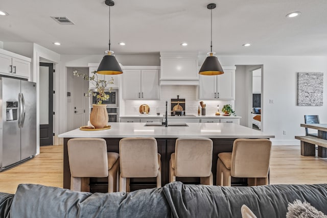 5219 Old Dennis Rd, Weatherford, TX 76087 - kitchen with stainless steel fridge with ice dispenser, open floor plan, a sink, decorative backsplash, and recessed lighting
