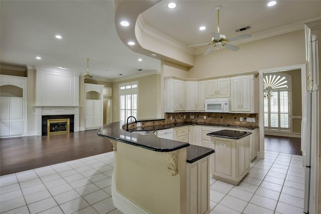 7712 Ravenswood Rd, Granbury, TX 76049 - kitchen featuring white appliances, ornamental molding, a peninsula, a sink, and light tile patterned floors