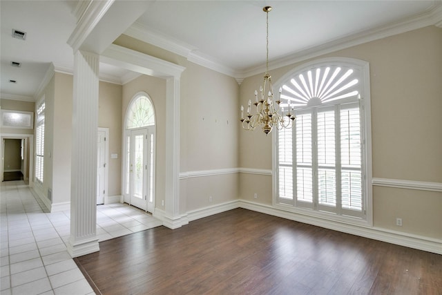 7712 Ravenswood Rd, Granbury, TX 76049 - foyer with ornate columns, wood finished floors, a chandelier, baseboards, and crown molding