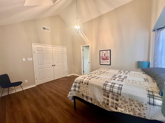 bedroom with a chandelier, wood finished floors, baseboards, high vaulted ceiling, and a closet