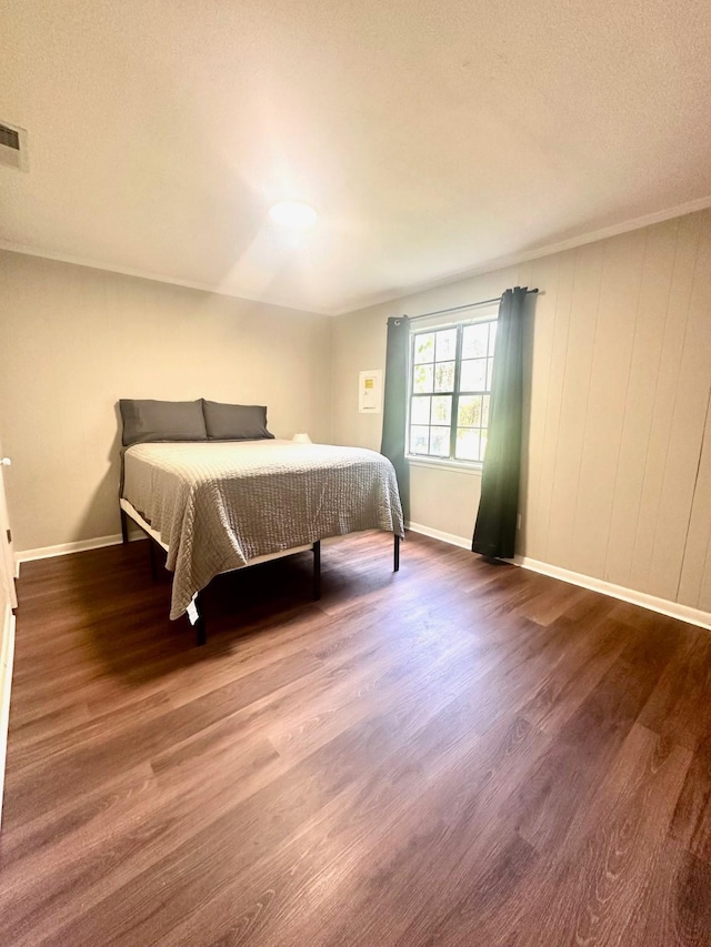 bedroom with wood finished floors and baseboards