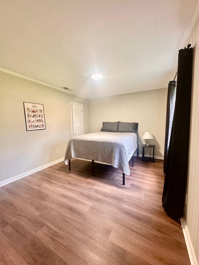 bedroom featuring wood finished floors and baseboards