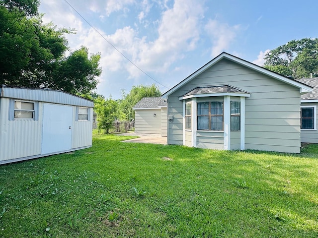 view of yard featuring a storage shed, an outdoor structure, and a patio