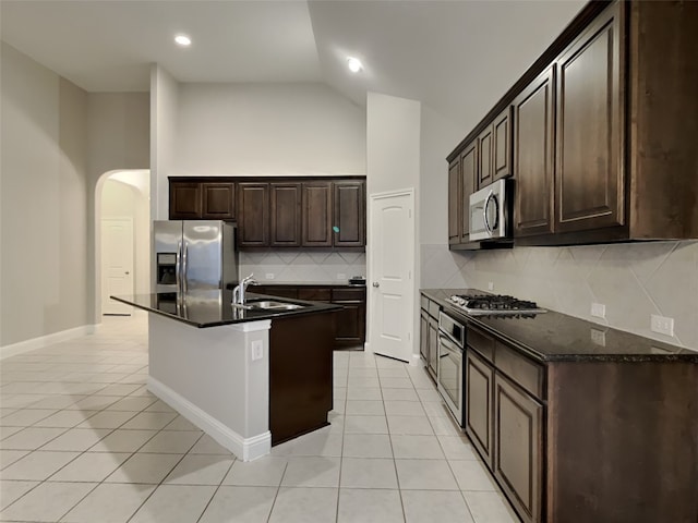 5116 Stockwhip Dr, Fort Worth, TX 76036 - kitchen featuring stainless steel appliances, a sink, light tile patterned floors, arched walkways, and high vaulted ceiling